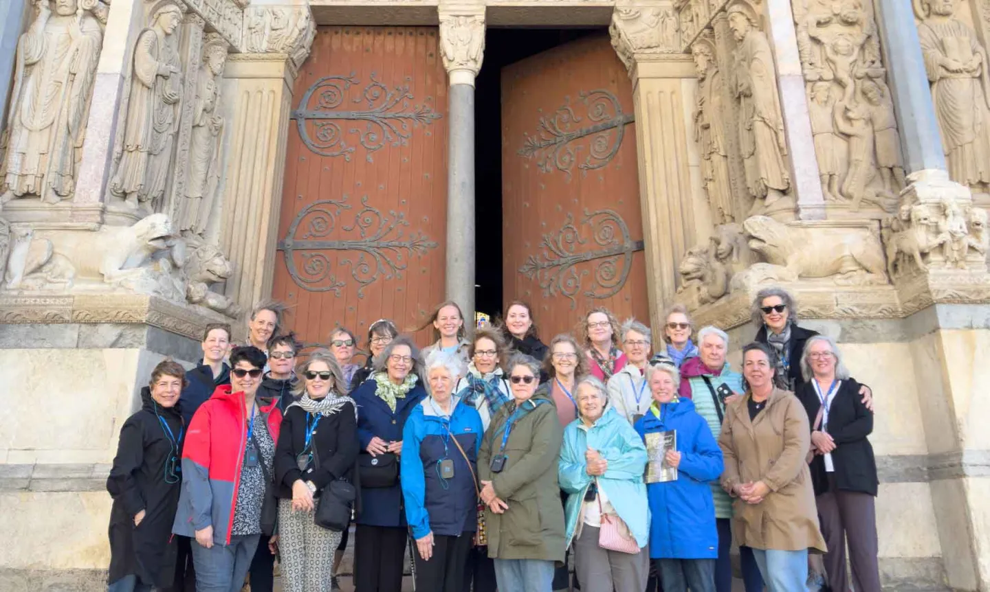 A group of alumni standing outside the doors to a cathedral.