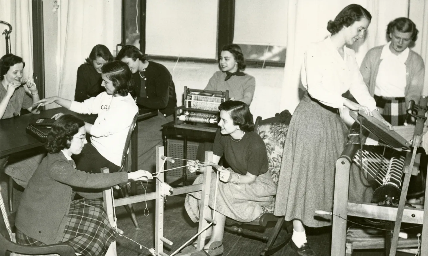 A 1950, black-and-white photo of St. Kate's students practicing occupational therapy skills with craft looms.