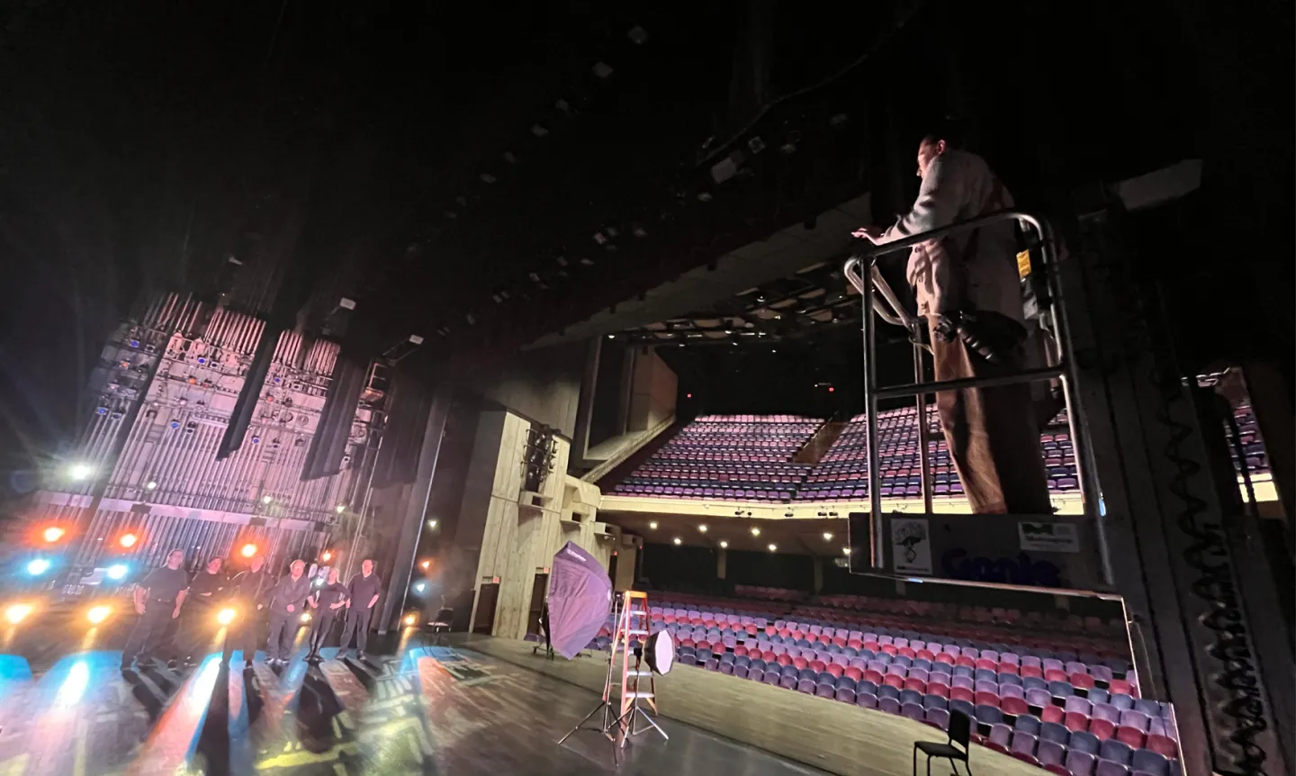 Photographer Rebecca Zenefski Slater ’10 stands on a crane shooting The O'Shaughnessy production crew onstage.