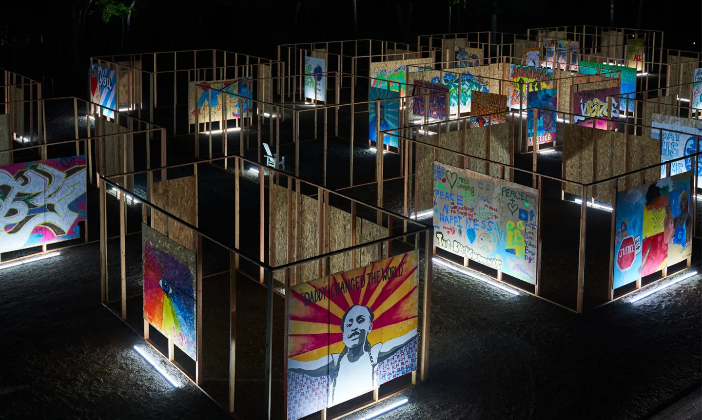 Photo from exhibition "Aftermath," featuring an array of plywood murals