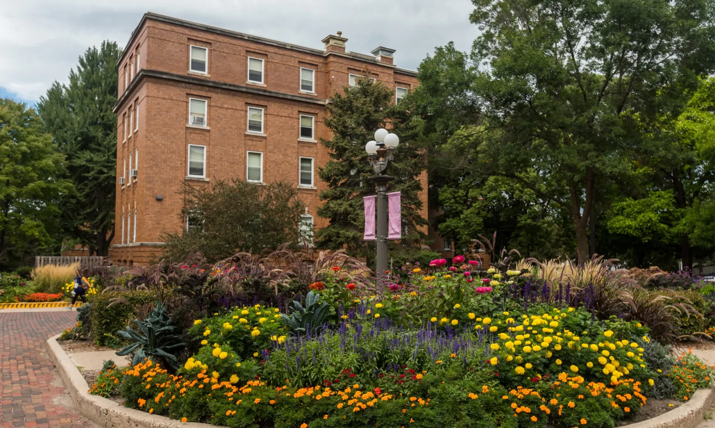 An exterior shot of Whitby featuring different flowers in front of the building.