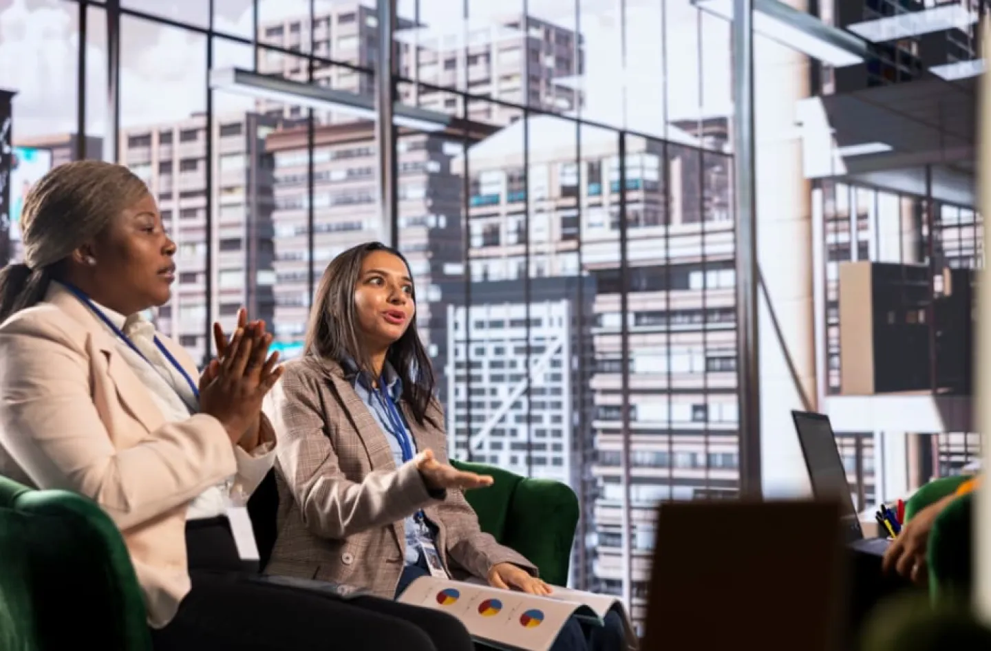 Two women business leaders meet with their team to discuss a project. 