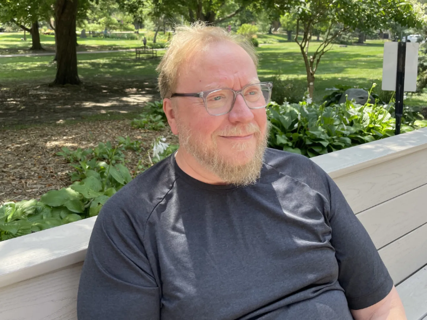 white man with glasses and gray shirt smiling