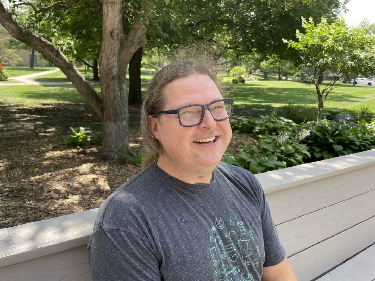white male with glasses and long hair smiling