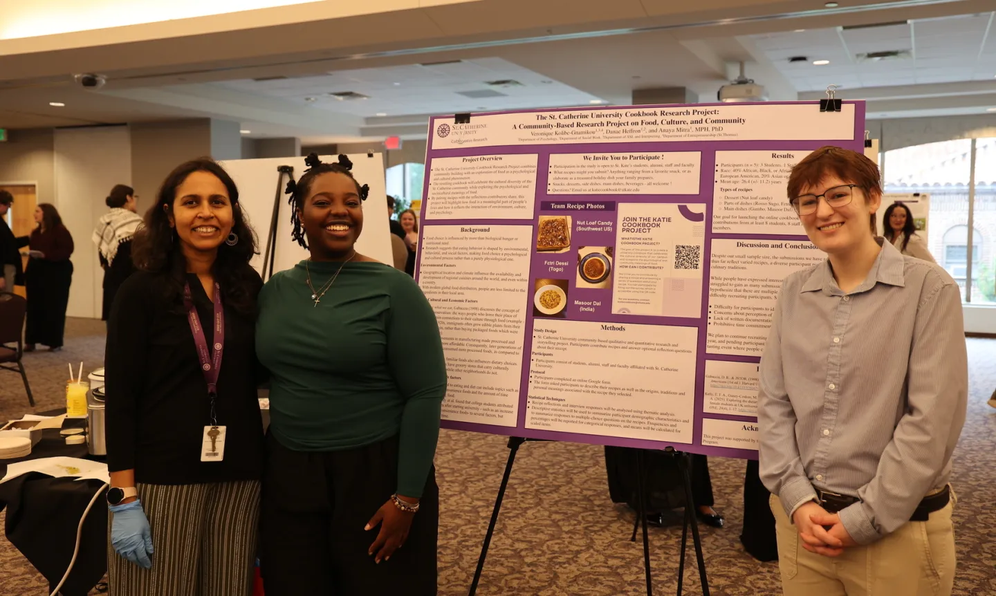 Two Summer Scholars students and a faculty mentor stand in front of a poster with their research.