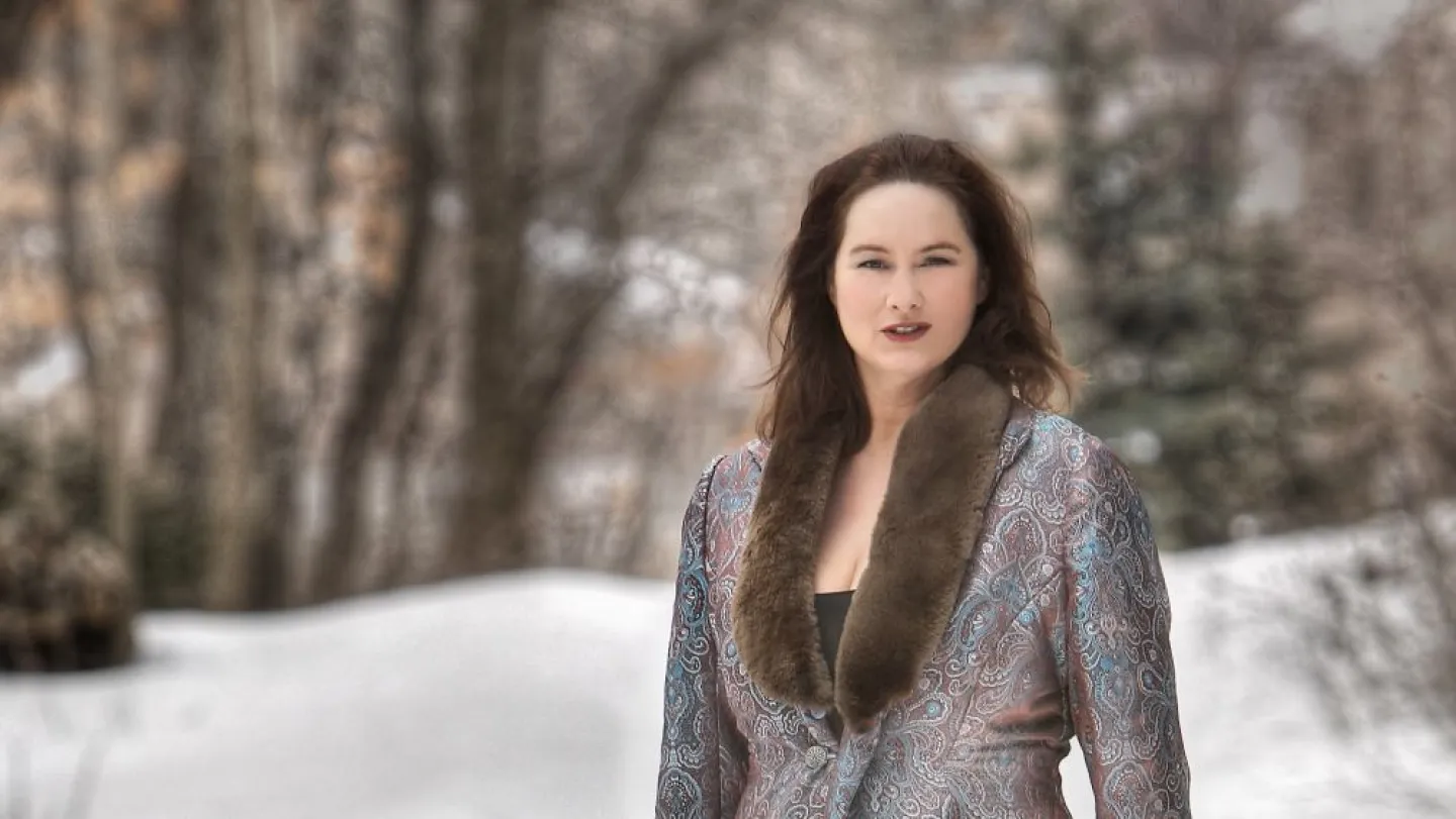 Portrait of Katie McMahon in fur collar coat against a snowy scene.