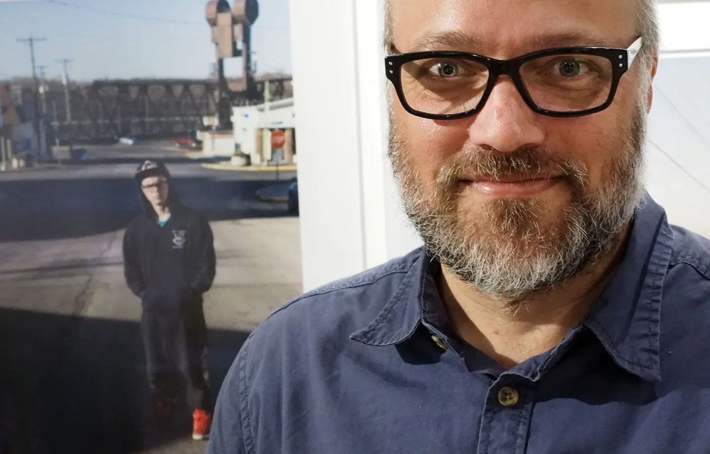Photographer and Associate Professor Todd Deutsch with one of his photographs from a 2016 exhibit at the Catherine G. Murphy Gallery. Photo by Brad Stauffer